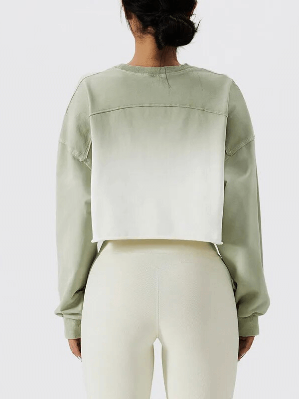 Back view of a woman wearing a gradient color long sleeve O-neck crop top; ideal for sports and casual wear. Made of breathable cotton.